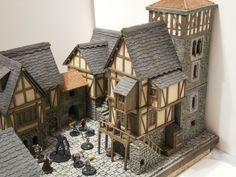 a model of a medieval village with figures and buildings