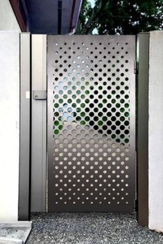 an open metal gate with circular holes on the door and side panels that have been cut in half