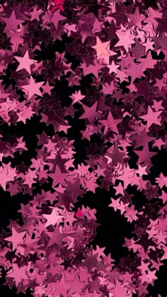 many pink stars are flying in the air