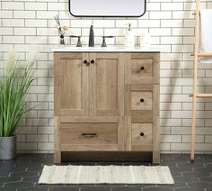 a bathroom vanity with two drawers and a mirror above it in front of a white tiled wall