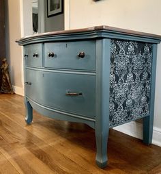 an old dresser painted blue with black and white designs