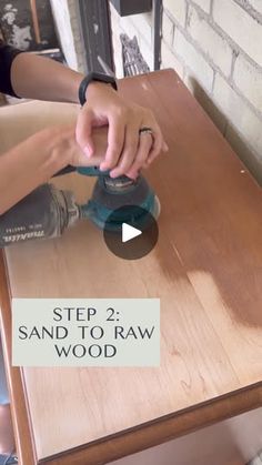 a person sanding wood on top of a wooden table