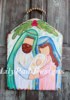 a painting on the side of a wooden door depicting jesus and mary holding a baby jesus