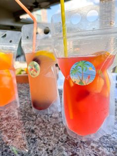 three glasses filled with drinks sitting on top of a counter next to each other,