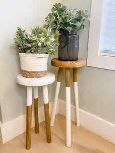 two small wooden stools with plants on them