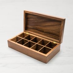 an open wooden box with compartments on a marble surface