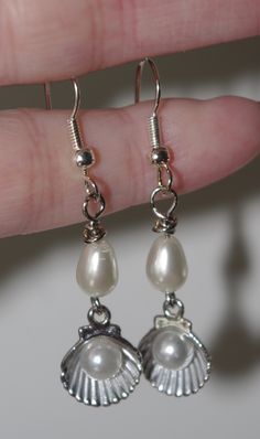 "Handmade Earrings: Silver Scallop Shells with Pearls I found these little vintage silver metal scallop shells with the pearls already in them and added the teardrop-shaped pearls to take them to the next level. I hope you like them...I think they are adorable! The charm is 1.25\" long; the earring from the top of the hypo-allergenic ear wire to the bottom of the shell is 2\" long." Vintage Metal Pearl Earrings As Gift, Vintage Metal Pearl Earrings For Gift, Silver Metal Clip-on Earrings With Pearl Drop, Silver Clip-on Earrings With Pearl Drop, Nickel-free Vintage Pearl Earrings As Gift, Vintage Nickel-free Pearl Earrings For Gift, Silver Metal Pearl Earrings As Gift, Silver Pearl Earrings As Gift, Silver Pearl Earrings For Gift