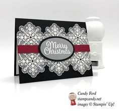 a white and black christmas card with snowflakes on the front, red ribbon around the edges