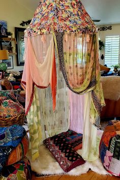 a canopy bed covered in colorful fabrics and curtains