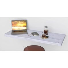 a laptop computer sitting on top of a wooden desk next to a cup of coffee