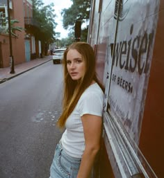 a woman leaning against the side of a truck