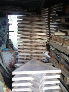 stacks of wooden boards stacked on top of each other in a room filled with wood pallets