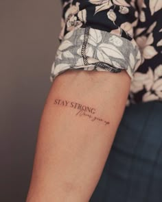 a woman's arm with a tattoo saying stay strong on the left side of her arm