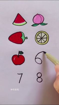 someone is drawing fruit and vegetables on paper