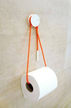 an orange and white toilet paper holder attached to a wall with a roll of toilet paper