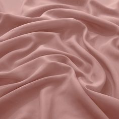 a bed covered in pink sheets and pillows