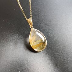 ITEM DESCRIPTION: >>The pendant is made from Solid 14K Yellow Gold. Gemstone used is absolutely natural and ethically sourced. >>Natural Golden Rutile in cabochon cut and pear shape with bezel setting is studded on it with utmost precision. >>This is a minimalist design and is absolutely hassle-free and everyday jewelry. Gem: Golden Rutile Gem size: 12x17 mm Gem weight: 10.36 carats Gold purity: 14K (58.33% approx.) Gold weight: 0.69 grams Gross weight: 2.72 grams The Gold purity is guaranteed a Yellow Gold Teardrop Gemstones For Anniversary, Anniversary Yellow Gold Teardrop Gemstones, Yellow Gold Gemstone Pendant Necklace, Yellow Gold Pendant Necklace With Gemstone, 14k Gold Teardrop Pendant Jewelry With Polished Finish, Yellow Gold Drop Gemstone Jewelry, Teardrop 14k Gold Jewelry With Natural Stones, 14k Gold Teardrop Jewelry With Natural Stones, Hallmarked Yellow Gold Gemstones For Gift