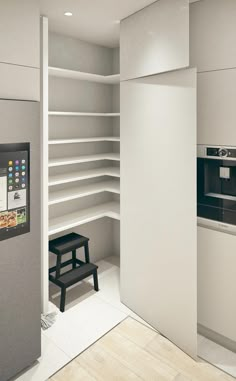 an empty kitchen with white shelving and a black stool in the corner next to it