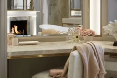 a bath room with a sink a mirror and a fire place in the fireplace area