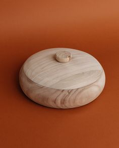 a round wooden object on an orange background