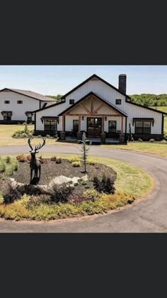 a large house with a deer statue in the middle of it's front yard