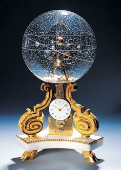 a clock that is sitting on top of a stand in the shape of a globe