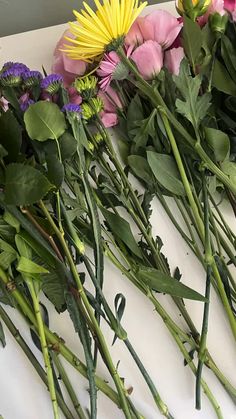 flowers are laid out on a table to be used as florist bouquets