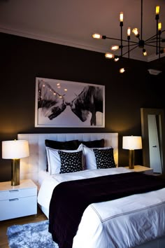 a bedroom with black and white bedding, two nightstands and a painting on the wall