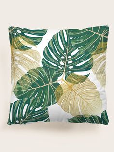 a white pillow with green and yellow leaves on it