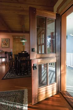 an open door leading to a dining room and living room with sliding glass doors on both sides