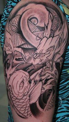 a woman's arm with a dragon and rose tattoo on the left side of her body