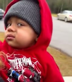 a young child wearing a red hoodie and looking up