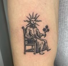 a tattoo on the arm of a person sitting in a chair