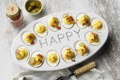 an egg tray with deviled eggs on it and the words happy written in large letters