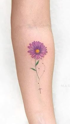 a woman's arm with a purple flower tattoo on the left side of her leg