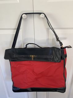 a red and black purse hanging on a door