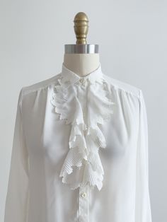 A darling silky white blouse, with jabot style ruffles with embroidered edges. ☛ m e a s u r e m e n t s ☚ Best for: XS-S Bust: 34 Waist: 34 Shoulders: 14 Length: 24 ☛ d e t a i l s ☚ Era: 1980s Material: polyester Condition: excellent ☛ v i s i t   t h e   s h o p ☚ https://etsy.me/2Nd23kg ☛ instagram ┇ poppycockvintage ☛ facebook ┇ poppycockvintage Cottagecore Blouse, Cute Cottagecore, Lace Collar, 80s Vintage, Collar Blouse, White Blouse, Womens Clothing Tops, Favorite Outfit, Blouses For Women