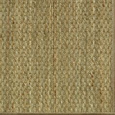 an area rug with brown and tan colors on the floor, it looks like woven fabric