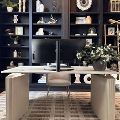 a home office with built - in bookcases, desk and computer monitor on it