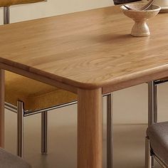 a wooden table with chairs around it and a bowl on top of the dining room table