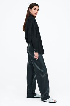 Our Ezra Shirt is a capsule wardrobe dream for your closet. Crafted from 100% crisp European poplin cotton, she offers a classic button-up silhouette in front, but with a cropped back for modern edge. Say hello, as well, to her diagonal seams at the front, sleek collar and long dolman sleeves finished with mother-of-pearl button cuffs. Wear Ezra tucked, tied or open and free—she never fails to inspire new looks.[SPLIT] Rocio, in black and in light blue, is 5'9.5" (175 cm) tall, wearing size XS. Modern Cropped Cotton Shirt For Work, Modern Cotton Cropped Shirt For Work, Modern Button-up Blouse For Fall, Modern Button-up Fall Blouse, Modern Collared Cropped Shirt For Work, Cropped Shirt For Workwear In Fall, Modern Long Sleeve Cropped Shirt For Work, Cropped Workwear Shirt For Fall, Relaxed Fit Cropped Shirt For Workwear In Fall