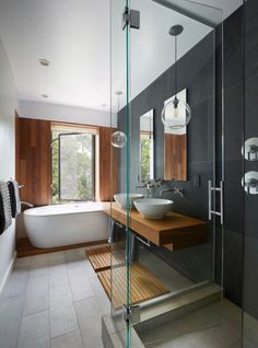 a bathroom with a glass shower door, sink and bathtub next to a window