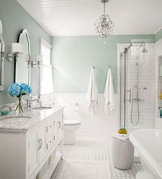 a white bathroom with two sinks and a bathtub