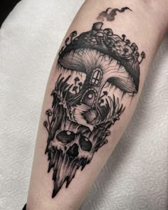 a black and white tattoo on the arm of a person with a mushroom house in it