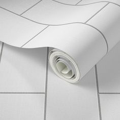 a white tile floor with a roll of paper on it