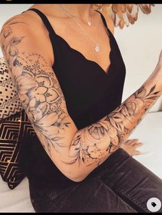 a woman with tattoos on her arms and arm holding a cell phone in her hand