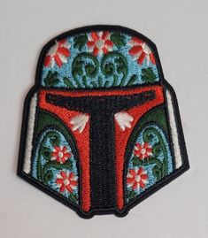 a star wars boba fett iron - on patch with flowers and leaves in the center