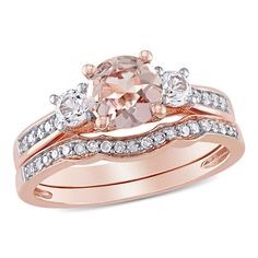 a pink diamond engagement ring set with two matching bands on the band, and an oval shaped