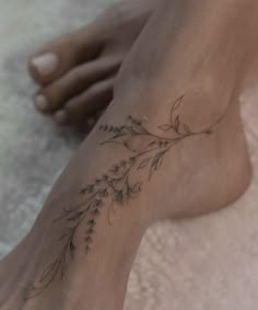 a woman's foot with a flower tattoo on her left side and the bottom part of her leg