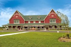 a large red building sitting on top of a lush green field